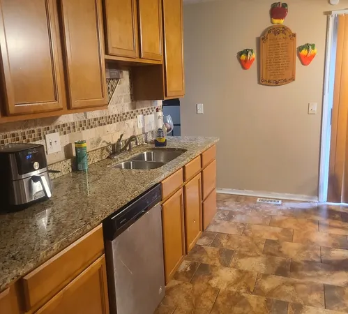 a kitchen with granite countertop a sink a stove and cabinets