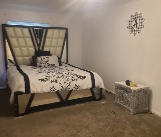 a bedroom with a bed a dresser and a window