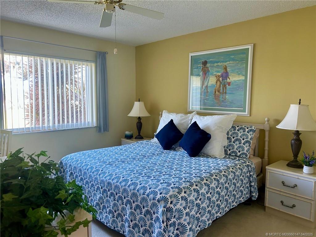 5811 Northeast Gulfstream Way, Unit 4002 Stuart, FL 34996 - Photo 13 of 39 a bedroom with a large bed and a window