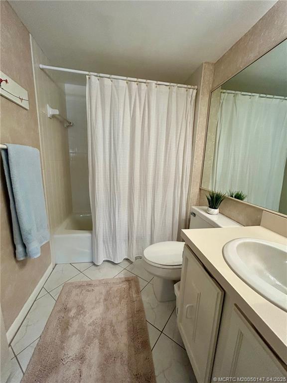 5811 Northeast Gulfstream Way, Unit 4002 Stuart, FL 34996 - Photo 14 of 39 a bathroom with a sink a toilet a mirror and shower curtain