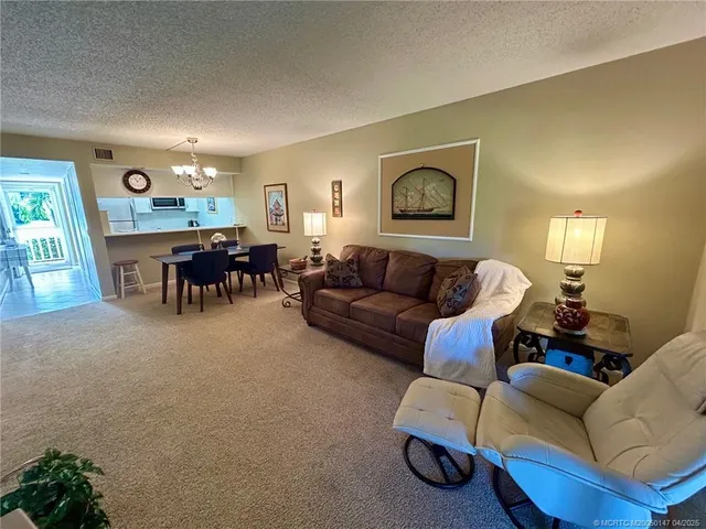 a living room with furniture a dining table and a painting on the wall
