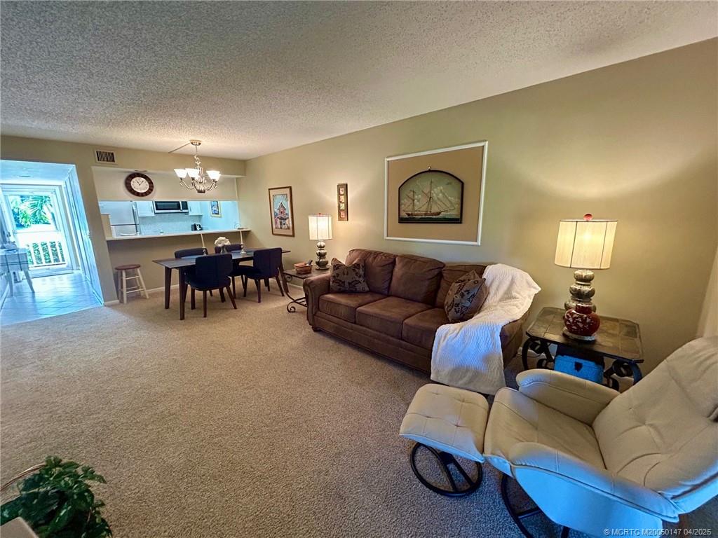 5811 Northeast Gulfstream Way, Unit 4002 Stuart, FL 34996 - Photo 18 of 39 a living room with furniture and a dining room