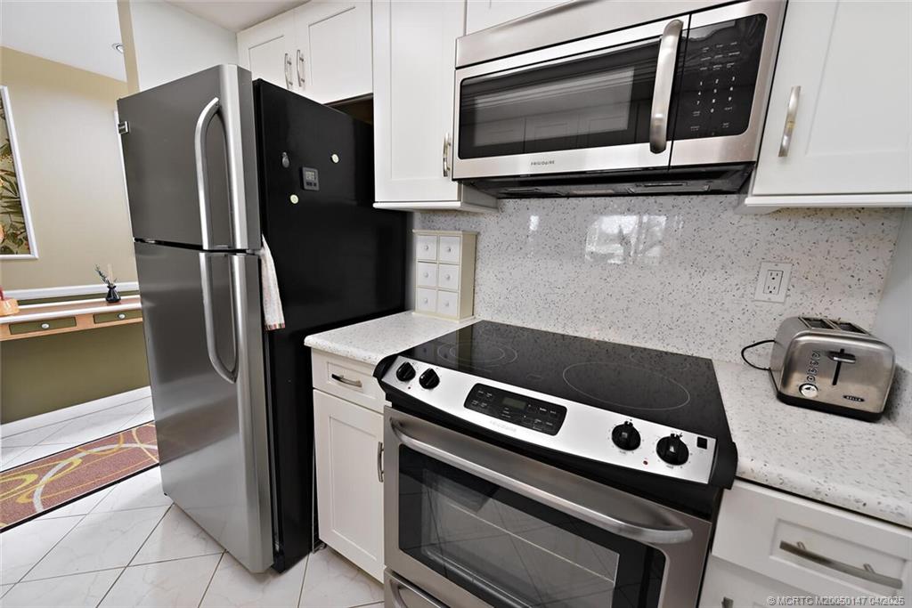 5811 Northeast Gulfstream Way, Unit 4002 Stuart, FL 34996 - Photo 10 of 39 a kitchen with a stove microwave and refrigerator