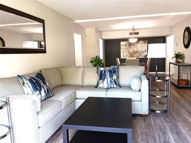 a living room with furniture and view of kitchen