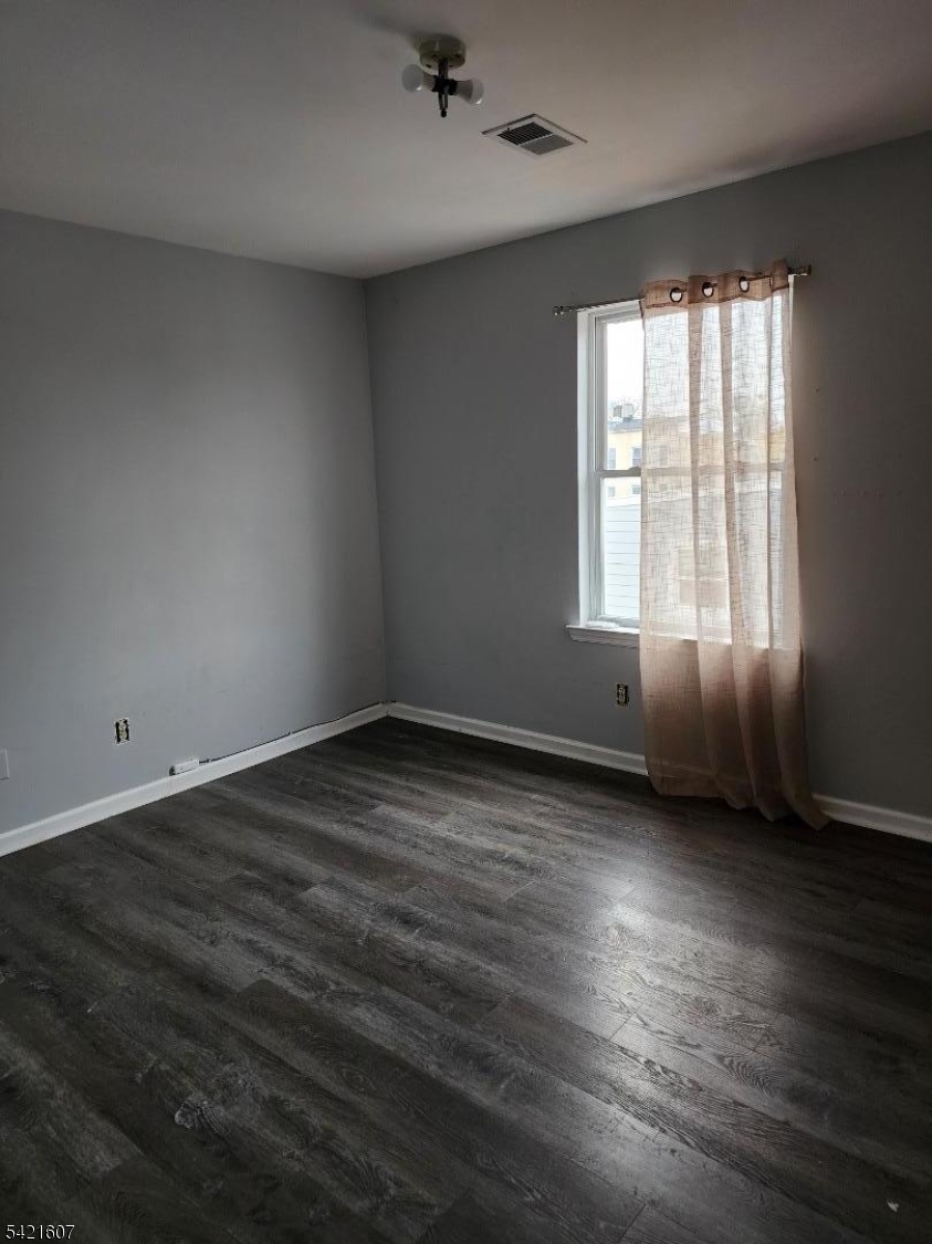 16 5th Street, Unit 2 Elizabeth Port, NJ 07206 - Photo 6 of 14 an empty room with wooden floor and windows