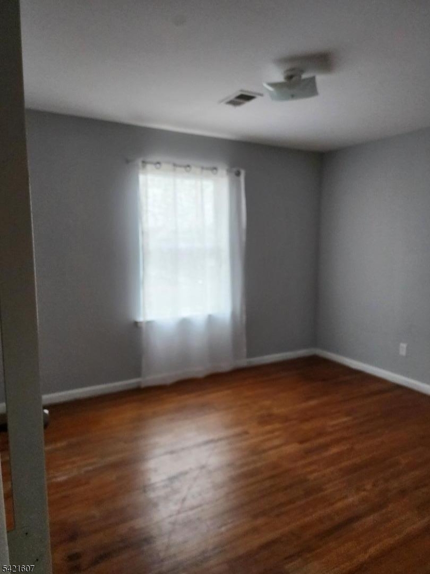 16 5th Street, Unit 2 Elizabeth Port, NJ 07206 - Photo 7 of 14 an empty room with wooden floor and windows