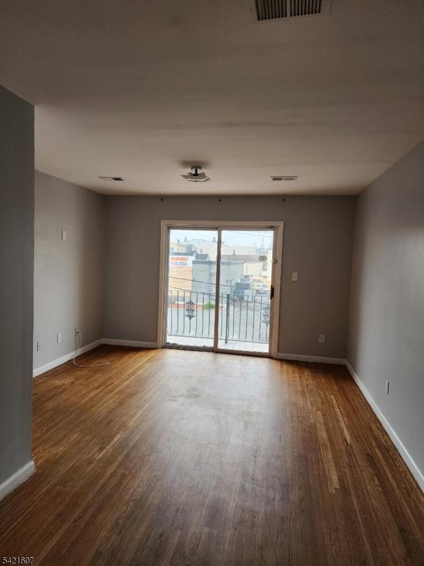 16 5th Street, Unit 2 Elizabeth Port, NJ 07206 - Photo 9 of 14 a view of an empty room with wooden floor and a window