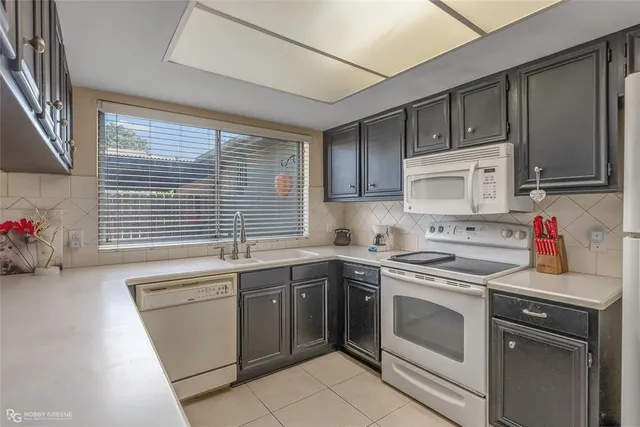 a kitchen with a sink stove top oven and cabinets
