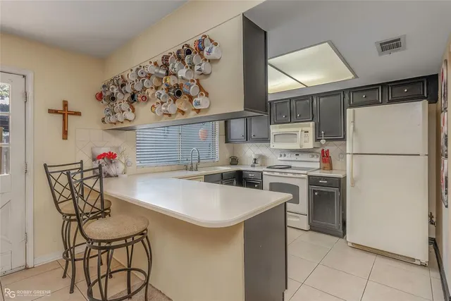 a kitchen with stainless steel appliances a refrigerator a stove a sink and white cabinets
