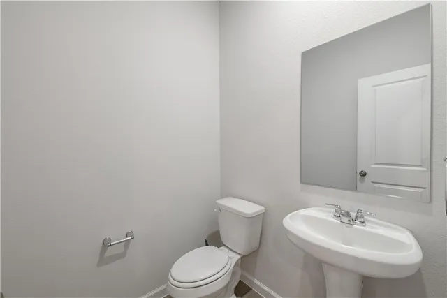 a bathroom with a sink a toilet and mirror