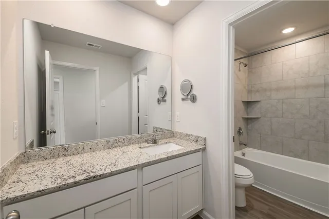 a bathroom with a granite countertop sink toilet and shower