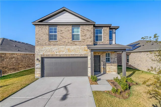 a front view of a house with a garden and plants