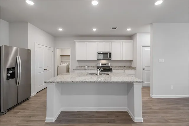 a kitchen with stainless steel appliances granite countertop a sink a refrigerator and a stove