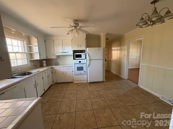 a kitchen with a sink a refrigerator and cabinets