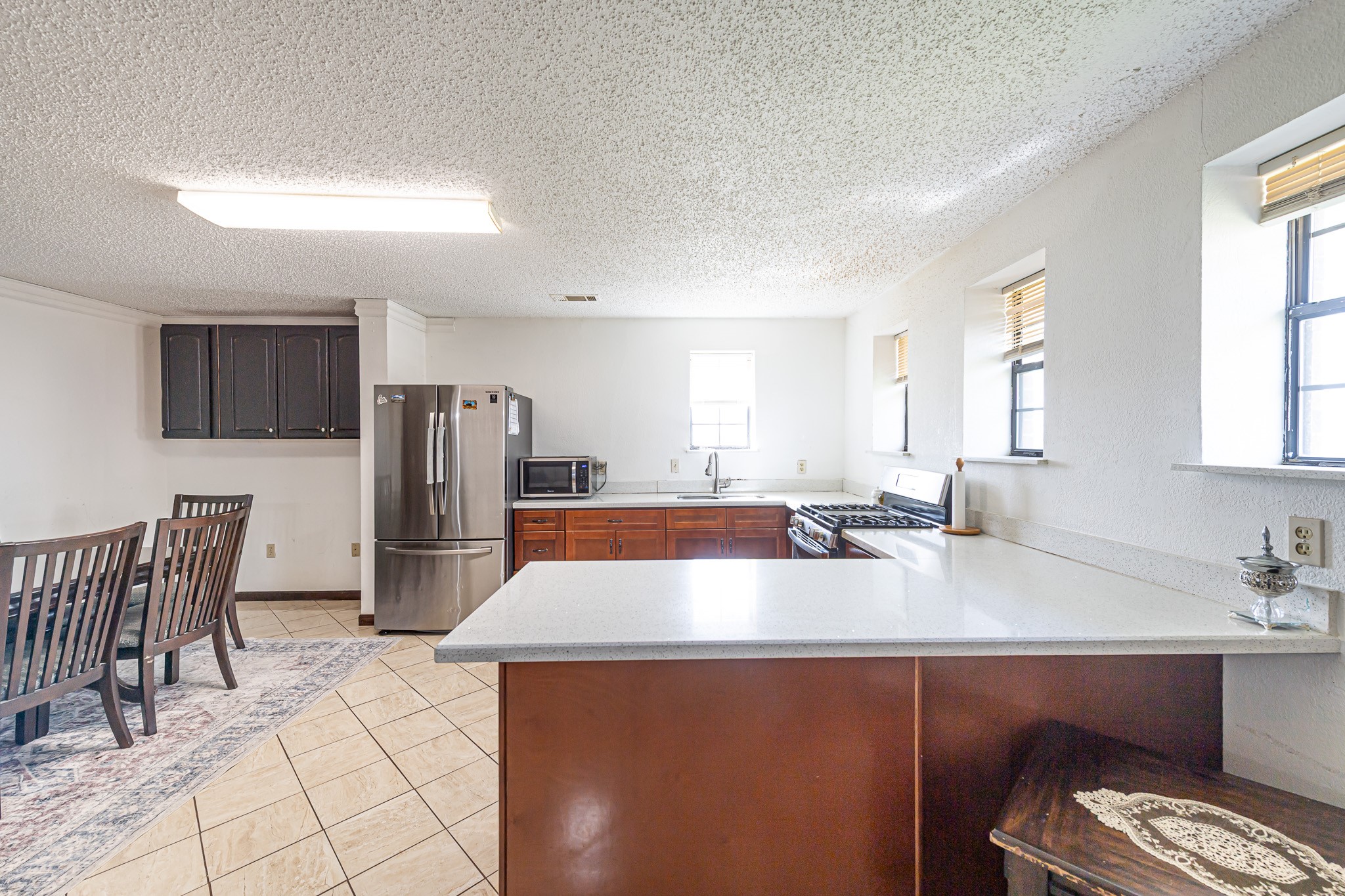 1195 Sens Road Sealy, TX 77474 - Photo 22 of 50 a kitchen with stainless steel appliances a refrigerator a sink a stove and white cabinets with wooden floor