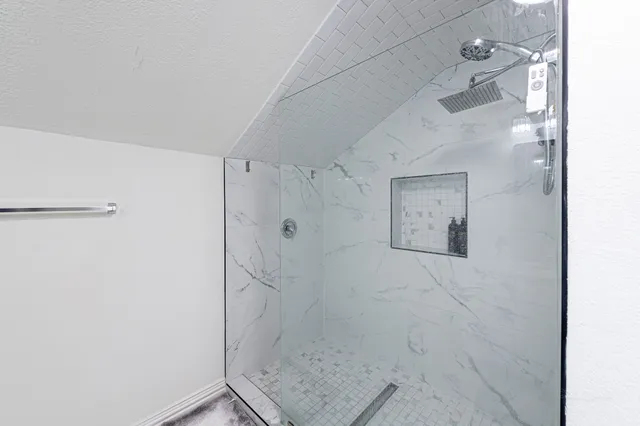 a bathroom with a granite countertop sink toilet and shower