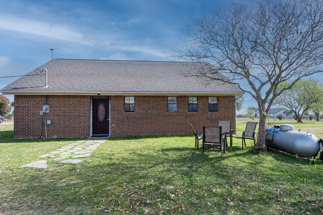 a backyard of a house with table and chairs
