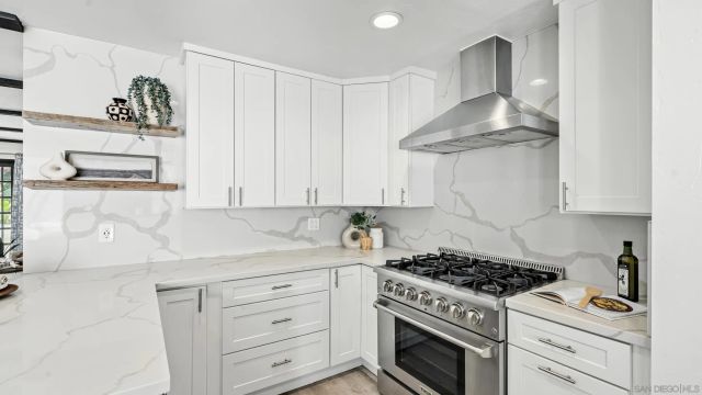 a kitchen with white cabinets and appliances