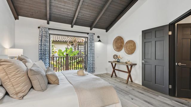 a bedroom with a bed a mirror and a large window