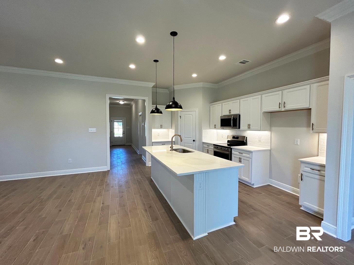 872 Sumter Loop Foley, AL 36535 - Photo 2 of 18 Kitchen with a center island with sink, sink, appliances with stainless steel finishes, and white cabinets