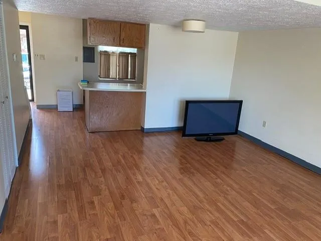 a living room with hard wood floors and a wooden floor