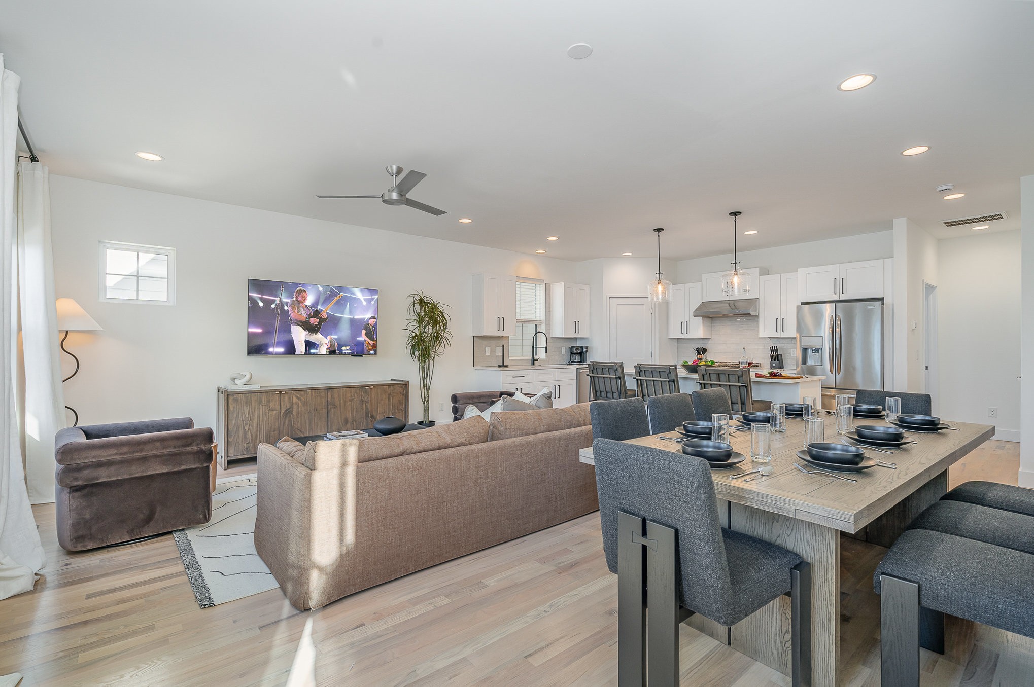 a view of a dining room with furniture a kitchen and chandelier