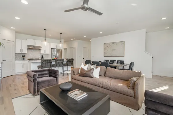 a living room with furniture and a view of kitchen