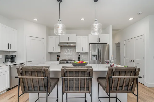 a kitchen with stainless steel appliances white cabinets and a stove top oven