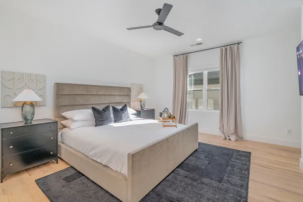 a white bed sitting in a bedroom next to a lamp