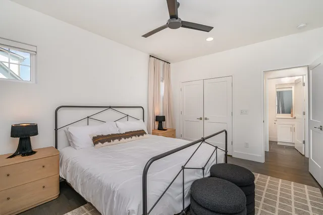 a bedroom with a bed and a lamp on the dresser