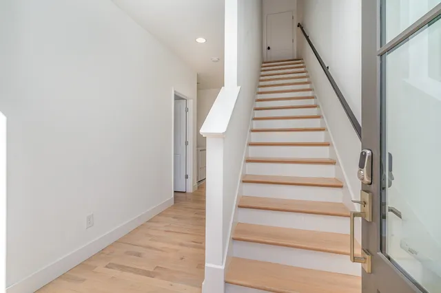 a living room with furniture large window and wall paintings