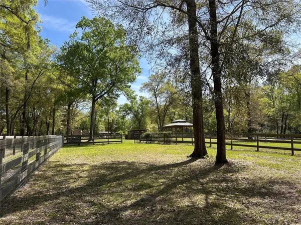 a view of a large swimming pool with a yard and large trees