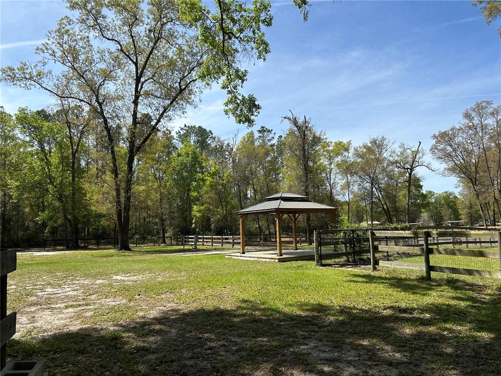 9290 Northwest 125th Avenue Ocala, FL 34482 - Photo 18 of 23 a view of a swimming pool with a table and chairs under an umbrella