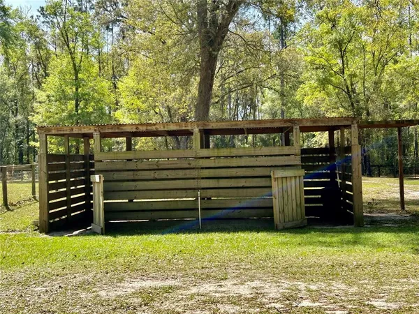 a view of a backyard with wooden fence and a large tree