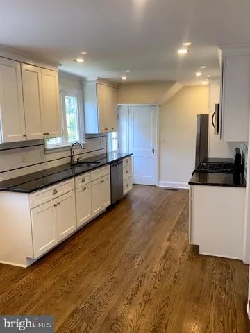 a kitchen with granite countertop a sink and cabinets