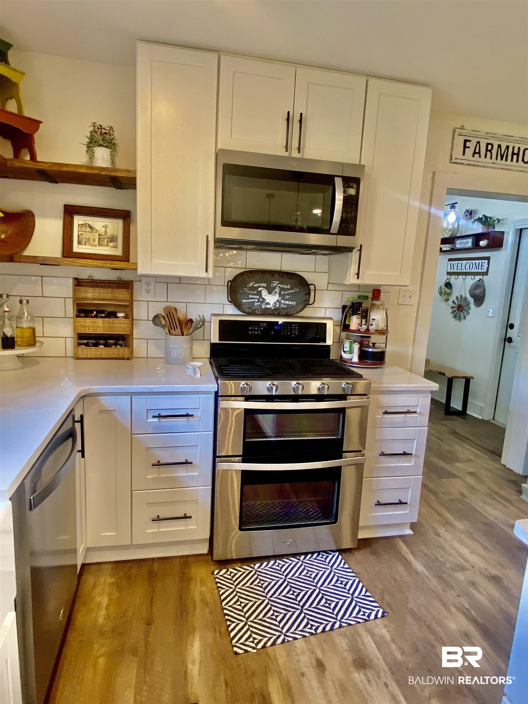 531 Highway 136 Monroeville, AL 36460 - Photo 15 of 48 Kitchen with white cabinetry, tasteful backsplash, light hardwood / wood-style floors, and appliances with stainless steel finishes