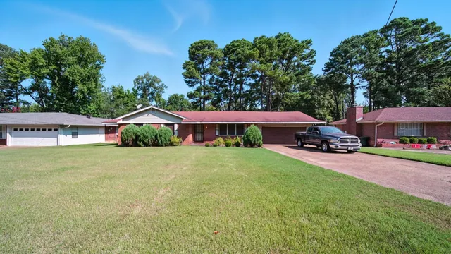 a couple of cars parked in front of yellow house