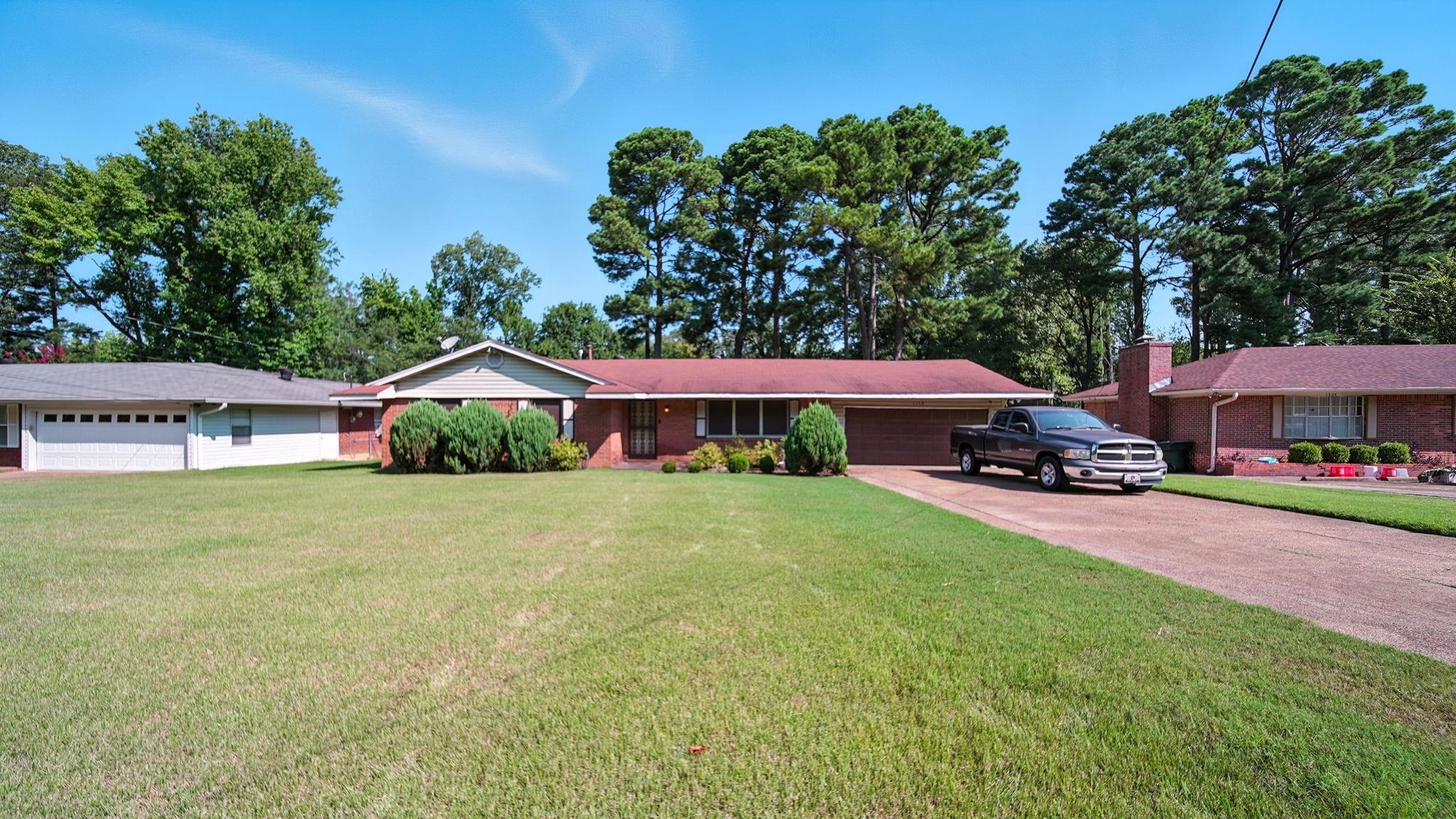 a couple of cars parked in front of yellow house