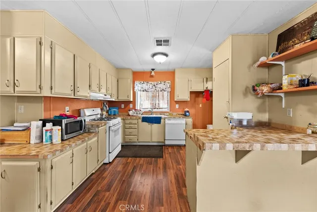 a kitchen with stainless steel appliances granite countertop a lot of counter space and wooden floors
