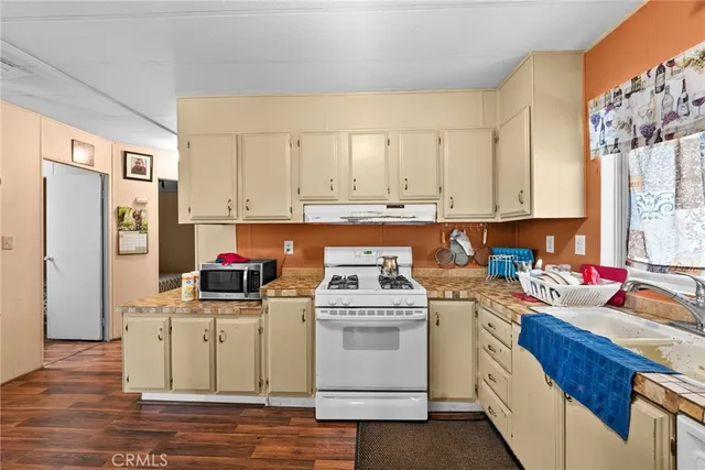 a kitchen with stainless steel appliances white cabinets sink and a stove
