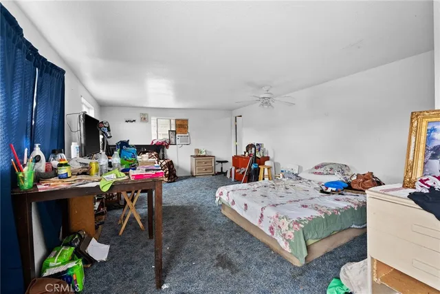 a bedroom that has a bed window and a table in it