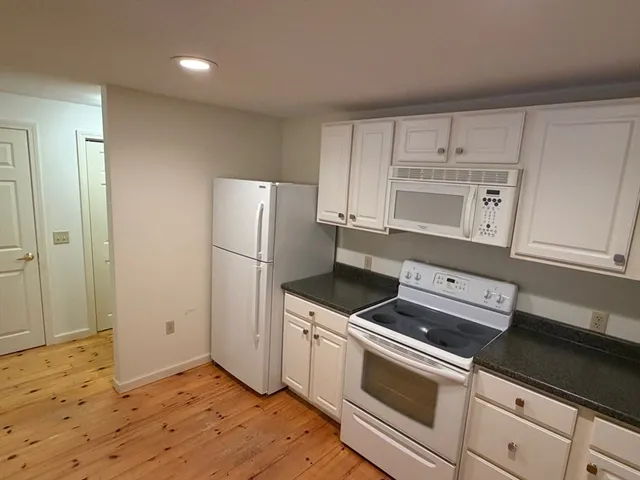 a kitchen with white cabinets and white appliances