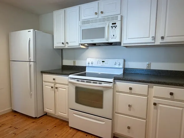 a kitchen with refrigerator a stove a microwave and cabinets