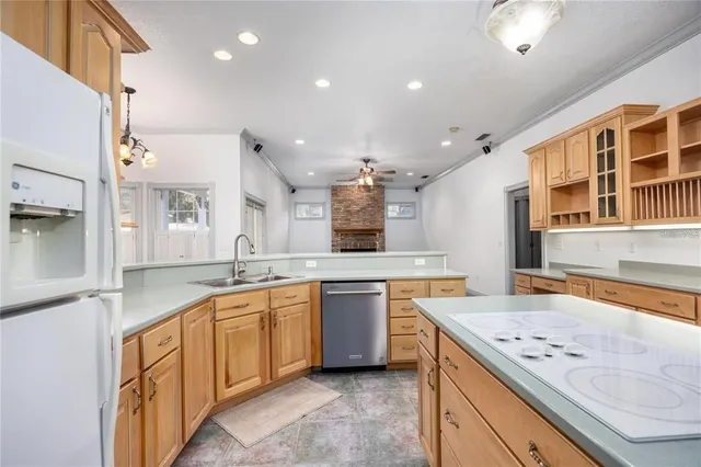 a large kitchen with stainless steel appliances a large counter top a stove a chimney a sink and cabinets