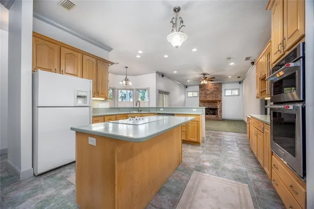 a view of an empty room with window and chandelier