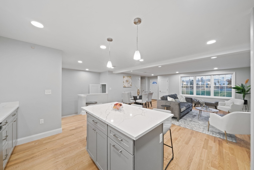 22 Simmonds Boulevard, Unit 22 Randolph, MA 02368 - Photo 8 of 28 a view of a kitchen with kitchen island a sink a counter top space and living room view