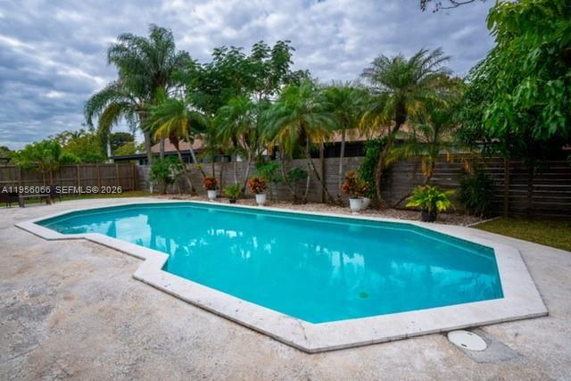 10210 Southwest 133rd Court Miami, FL 33186 - Photo 27 of 30 a view of a swimming pool with a lawn chairs and palm trees