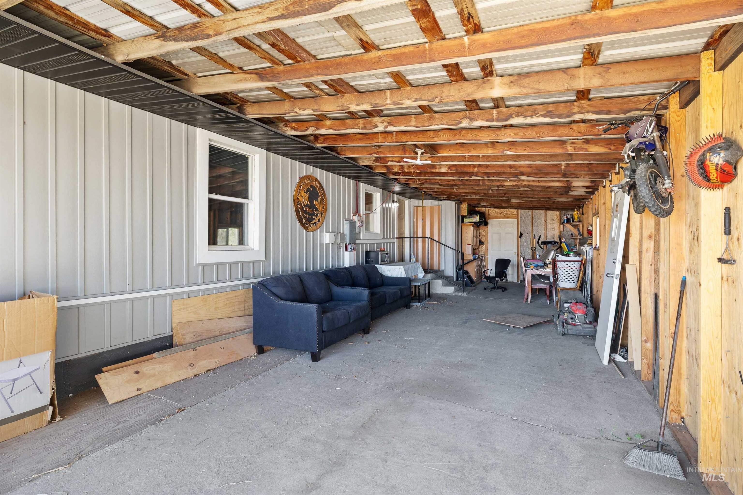 102 East 6th Street Rupert, ID 83350 - Photo 20 of 27 Spacious covered outdoor area featuring exposed wood beams and a corrugated metal ceiling
