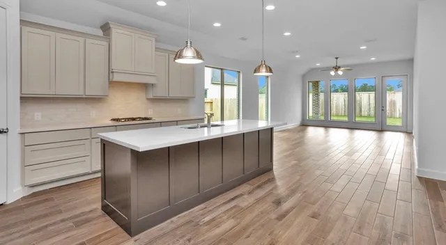 a large kitchen with stainless steel appliances granite countertop a large counter top a sink and a refrigerator