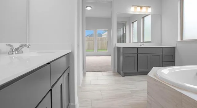 a bathroom with a tub sink and mirror